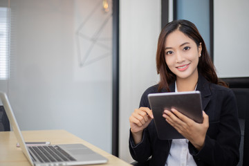 Asian business women using tablet  for working at office relax time and smiling