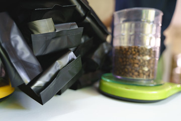 Packing roasted coffee beans to plastic bag