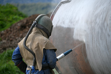 engineer sandblasting a steel casing - 300527165
