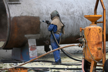 engineer sandblasting a steel casing