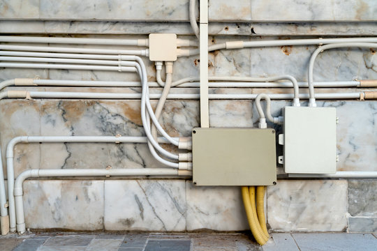 electrical junction boxes with plastic pipe connection on marble wall background