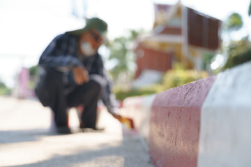 Asian worker painting no parking sign