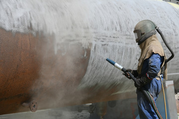 engineer sandblasting a steel casing