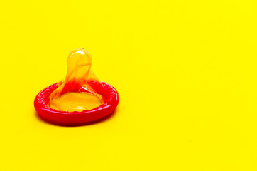 condom on a yellow background. The concept of safe sex.
