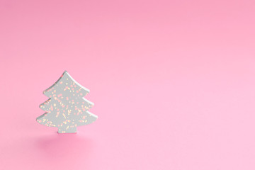 white wooden figure in the form of a fir tree on a pink background