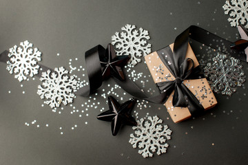 Merry Christmas and Happy Holidays greeting card, frame, banner. New Year. Noel. Silver Christmas decoration on black background top view. Winter holiday xmas theme