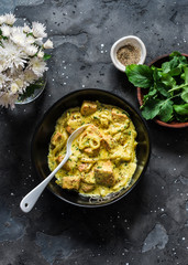 Curried creamy salmon with sauce on a dark background, top view
