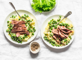 Beef steak with mashed potatoes and creamy green peas sauce on light background, top view