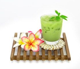 ice green tea milk in a glass and plumeria on panel isolated on white background