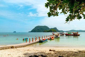 Plastic floating bridge extends into the sea with speed boat