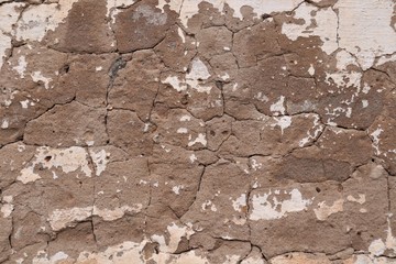 The surface is cracked plaster brown and white.