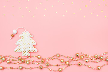 Decorative textile christmas tree and golden garland and stars on pink background. New Year or Christmas night concept. Top view Creative flat lay Template for you design, greeting card, invitation