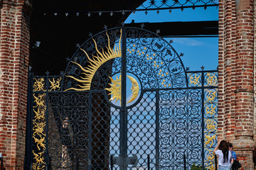 Beautiful forged gates with signs of the zodiac, the moon and the sun. Black metal gates.