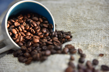 coffee beans in the white cup on the beige background