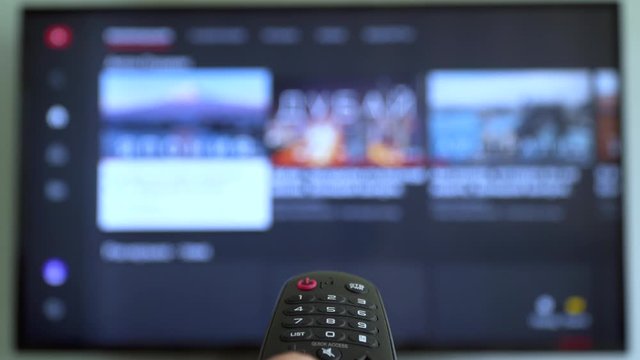 Smart tv screen and hand with remote control. Online video streaming service. Internet TV. Channel surfing