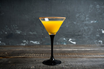 Autumn cocktail with pumpkin and orange juice in martini glass on the rustic background. Selective focus. Shallow depth of field.