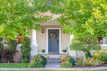 Foto op Canvas Front door of a home surrounded by leafy trees © Jason