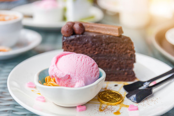 Strawberry ice cream scoop and Chocolate cake with blurred background, selective focus