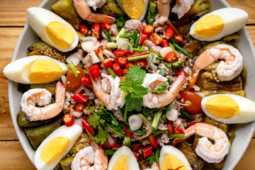 YUM , Spicy Thai food, Salad,Eggplant salad, fresh shrimp, boiled egg,Original Thai food, spicy grilled eggplants salad with boiled egg and shrimp in a banana leaf plate.