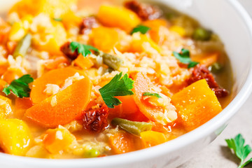 Vegetarian vegetable soup with lentils and pumpkin in white plate. Healthy vegan food concept.