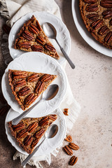 Pecan pie pieces on gray-brown background, flat lay. Vegan dessert concept.