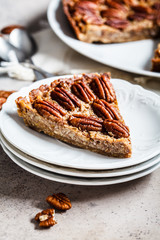 Piece of pecan Pie on gray-brown background. Vegan dessert concept.