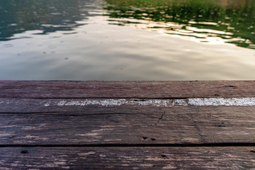 Empty wood floor with shimmering surface,Empty old wooden pier with ripple of lagoon water,Wooden desk over blue sea background vintage tone