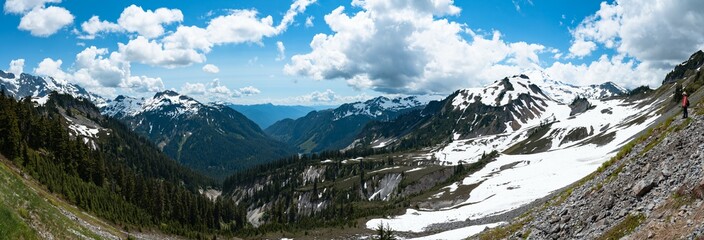 Panoramic view of snowcapped mountains and valley landscape with blue sky and clouds. Mt Shuksan, Mt Baker, Washington, USA