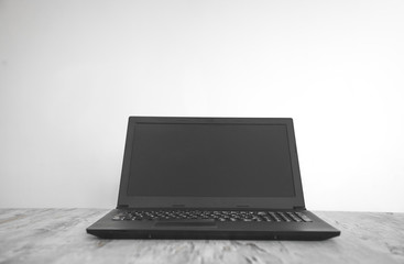 Black laptop on the office desk. Technology concept