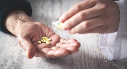 Hand of elderly woman with pills.