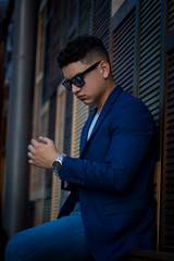 Fototapeta premium Joven con vestimenta casual y lentes viendo su reloj de mano