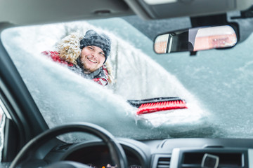 cleaning car after snow storm smiling man with brush