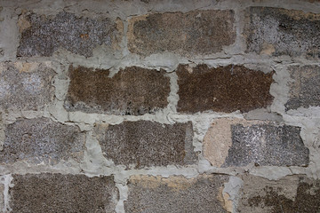 Gray block wall background. Grey textured building exterior surface with rough stacked big bricks. Tiled structure of stonewall for backdrop designs