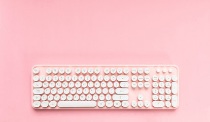 Computer keyboard isolated against pink background