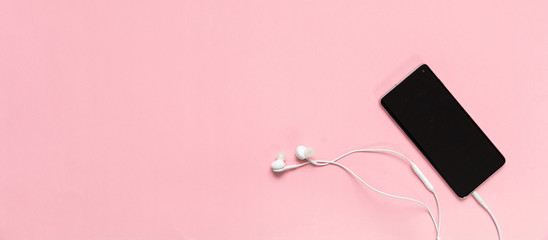Smartphone and earphones against pink background