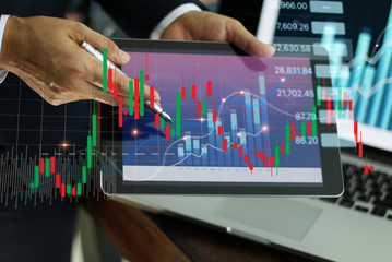 Businessman holding tablet and present financial stock market graph and economic growth chart,...