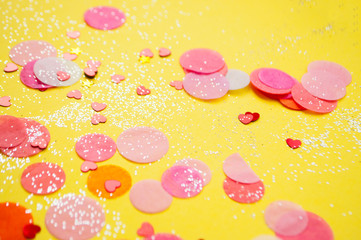 Colorful confetti, sparkles on bright yellow background. Festove background.