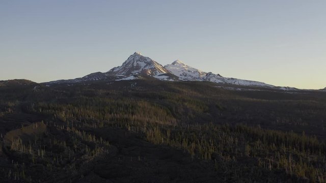 Aerial 4K HLG footage of high mountain lava field with view of Three Sisters mountains in Oregon