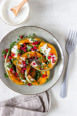 Grilled pumpkin with pomegranate and white sauce. Healthy eating.