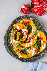 Grilled pumpkin with pomegranate and white sauce. Healthy eating.