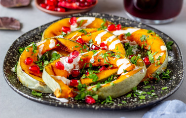 Grilled pumpkin with pomegranate and white sauce. Healthy eating.