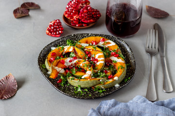 Grilled pumpkin with pomegranate and white sauce. Healthy eating.