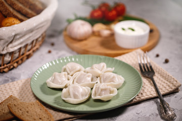 Obraz na płótnie Canvas Ravioli on a plate with vegetables and sauce. Boiled dumplings on a dish. Tasty dinner. Food.