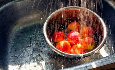 Apple washing in bowl, water pouring in kitchen sink, splashed water, copy space, fruits washing,...