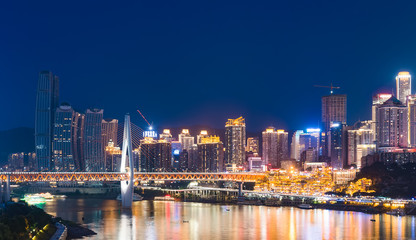 Naklejka premium chongqing city skyline at night, with bridge and river.