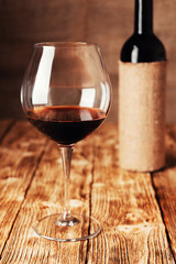 A glass of wine on a wooden table in the cellar of the winery