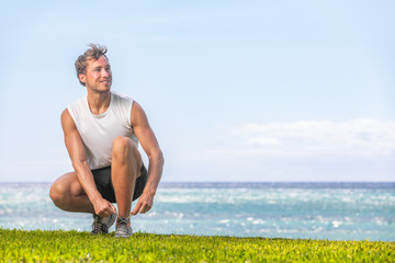 Happy healthy man getting ready to walk or jog on summer beach - Active lifestyle for weight loss runner going running outside.