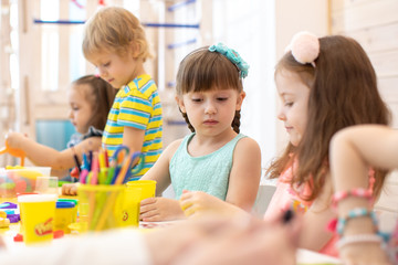 Group of preschool kids hands working in day care center or kindergarten