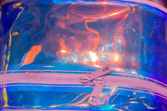 trendy neon holographic plastic baf with pink zip close up for backdrop