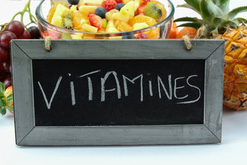 slate vitamins with fruits in the background